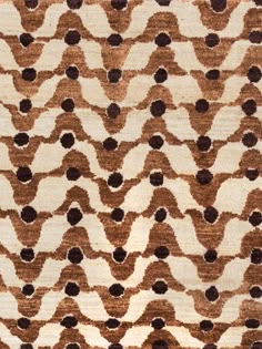 a brown and white rug with black dots on it