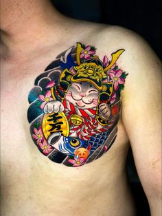 a man with a tattoo on his chest has a cat and fish design on it