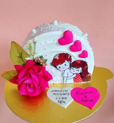 there is a cake decorated with hearts and flowers on the table next to a pink rose