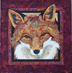 a close up of a quilt with a fox on it's face and eyes