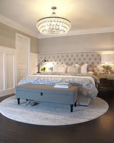 a bedroom with a round bed and chandelier above the headboard is shown