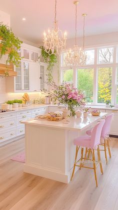 a kitchen with white cabinets and pink chairs in front of an island countertop that has flowers on it