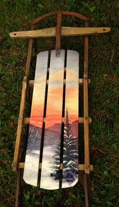 a wooden sled with a painting on it sitting in the grass