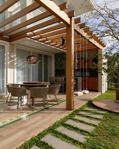 an outdoor dining area with patio furniture and wooden pergolated trellis on the side