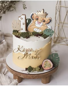 a birthday cake with a lion on top and the number one is decorated in gold