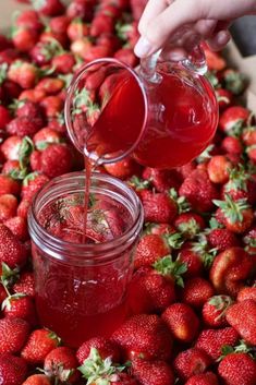 strawberries are being poured into a jar with the words strawberry simple syrup on it