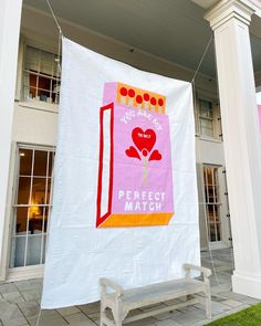 a banner hanging from the side of a building on a line with two benches in front of it