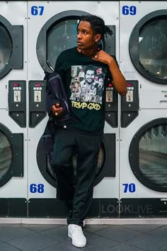 a young man standing in front of a stack of washers