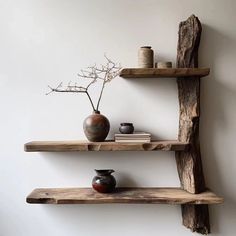 three wooden shelves with vases and books on them