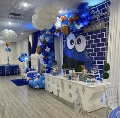 a blue and white baby shower party with balloons on the ceiling, cookies in the shape of an angry bird