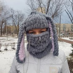 a person wearing a knitted animal mask in the snow