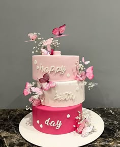 a three tiered cake with butterflies on top and happy birthday written on the side