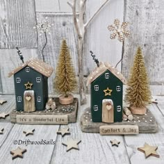 two small wooden houses with trees and stars