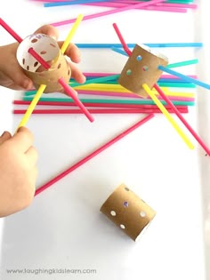 a child is making a craft with straws and paper