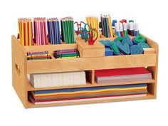 a wooden desk organizer filled with lots of different colored pencils and markers on top of it