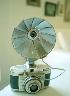 an old fashioned camera sitting on top of a table