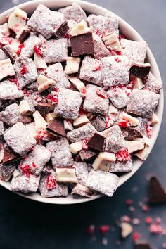 a white bowl filled with chocolate and marshmallows on top of a table