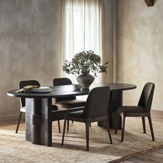 a dining room table with chairs and a potted plant