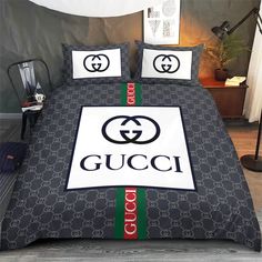 a bed with gucci logo on it and two pillows sitting next to each other