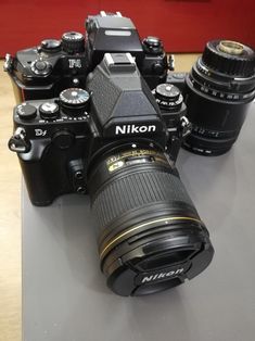 two cameras sitting on top of a table next to each other