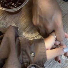 two hands holding each other while sitting at a table