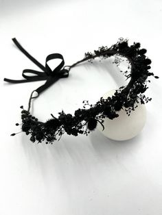 a white ball with black flowers on it and a ribbon tied around the headband