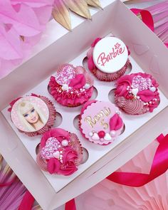 pink cupcakes in a box with barbie pictures on the top and happy birthday written on the bottom