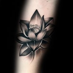 a black and white lotus tattoo on the arm