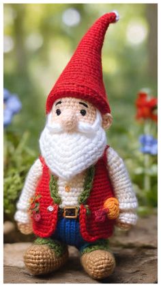 a small crocheted gnome sitting on top of a rock