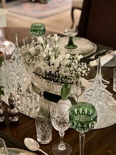 the table is set with glassware and flowers