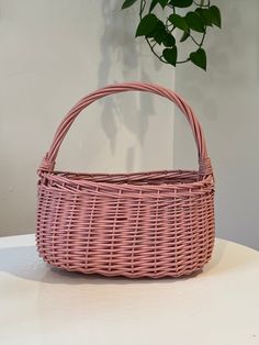 a pink wicker basket sitting on top of a table