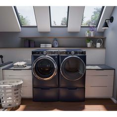 a washer and dryer in a small room with skylights above the windows