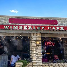 the front of a restaurant with people standing outside