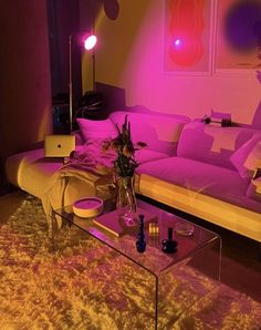 a living room filled with furniture and pink lighting