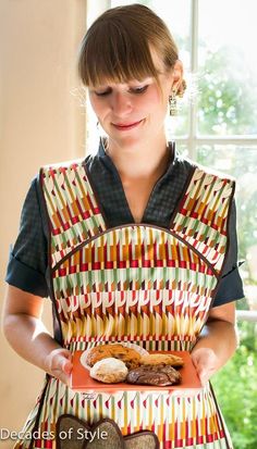 a woman in an apron holding a sandwich