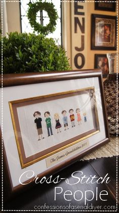 cross stitch people framed in front of pine cones