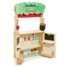 a wooden toy store with shelves and chalkboard on the front, including an apple tree