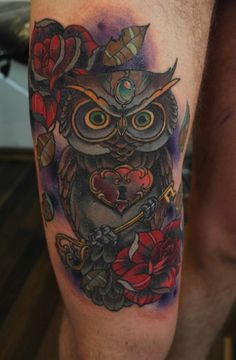 an owl tattoo on the leg with flowers and hearts around it's eyes is shown