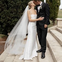 a bride and groom kissing on the steps