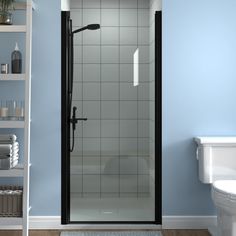 a white toilet sitting next to a shower in a blue walled bathroom with shelves on the wall