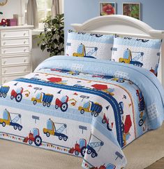 a child's bed with blue and white comforter, pillow cases and pillows