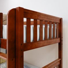 a wooden bunk bed sitting next to a white wall