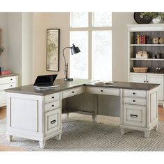 a white desk sitting on top of a hard wood floor next to a large window