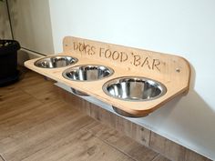 a wooden sign that says dogs food bar with three bowls on the front and bottom