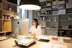 a woman sitting at a desk in front of a computer