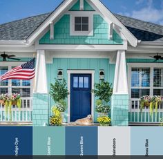 a blue house with an american flag on the front door and window sill above it