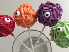 four colorful lollipops with googly eyes on them