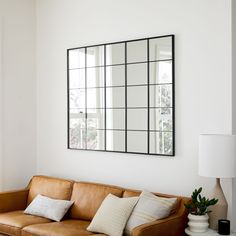 a living room with a couch and mirror on the wall