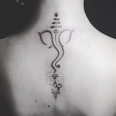 the back of a woman's neck with an intricate gandap tattoo on it