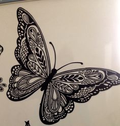 a drawing of a butterfly on a white wall with black and white designs in the background